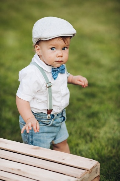 stock-photo-portrait-cutie-hat-shirt-shorts-bow-with-suspenders-looking-camera-while-walking-green-lawn-backyard-looking-camera-with-curiosity_132075-10335.jpg