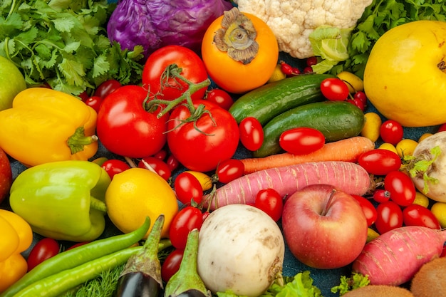 top-view-fruits-vegetables-eggplant-bell-peppers-apples-carrot-coriander-cauliflower-persimmon-radish-cherry-tomatoes-blue-background_140725-145434.jpg
